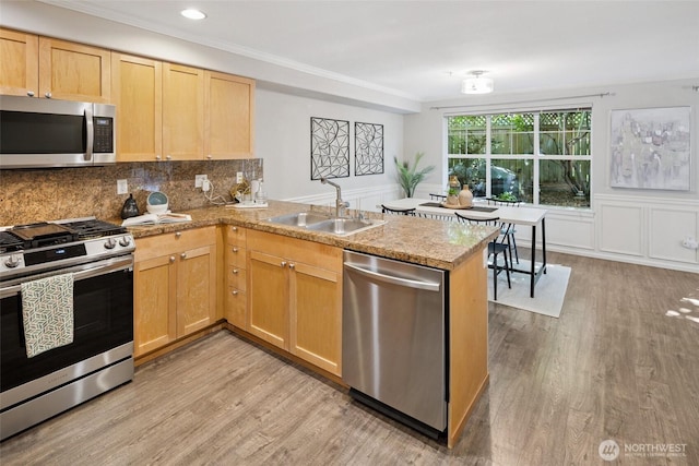 10549 Stone Ave N Unit 101, Seattle, WA 98133 - kitchen with appliances with stainless steel finishes, a peninsula, light wood finished floors, ornamental molding, and light brown cabinetry