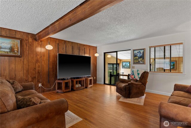 2434 NW Alan Ave, East Wenatchee, WA 98802 - living room featuring a textured ceiling, wood walls, light wood finished floors, and beamed ceiling