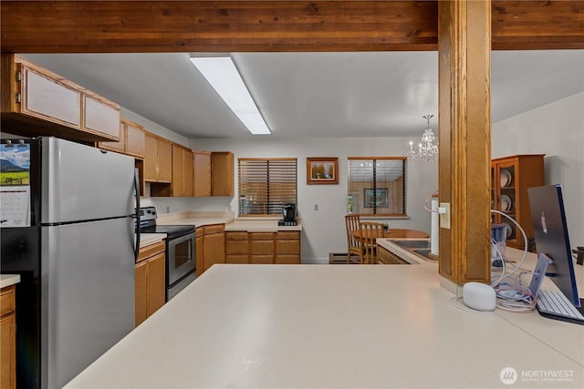 2434 NW Alan Ave, East Wenatchee, WA 98802 - kitchen with stainless steel appliances, light countertops, and a chandelier