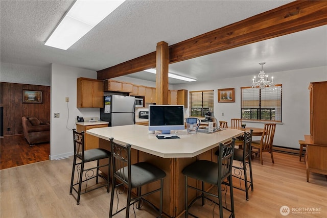 2434 NW Alan Ave, East Wenatchee, WA 98802 - kitchen featuring appliances with stainless steel finishes, light wood-style floors, a textured ceiling, light countertops, and a chandelier