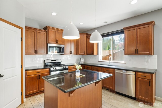 502 182nd St E, Spanaway, WA 98387 - kitchen with stainless steel appliances, a kitchen island, recessed lighting, brown cabinetry, and a breakfast bar area
