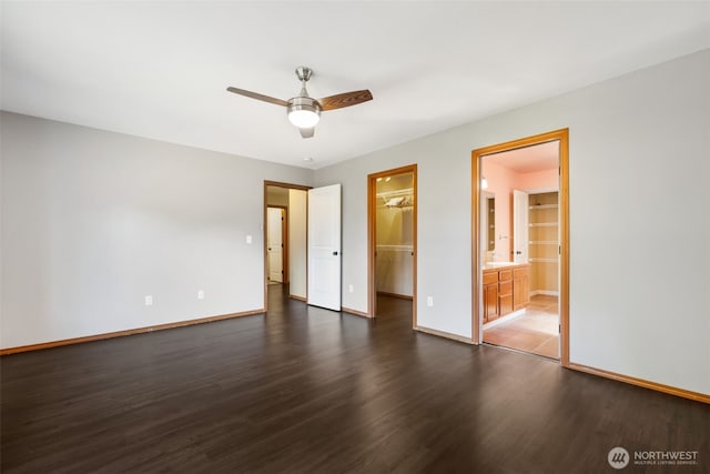502 182nd St E, Spanaway, WA 98387 - unfurnished bedroom featuring a walk in closet, dark wood-style flooring, a closet, a ceiling fan, and ensuite bath
