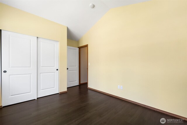 502 182nd St E, Spanaway, WA 98387 - unfurnished bedroom featuring dark wood-style flooring, vaulted ceiling, and a closet