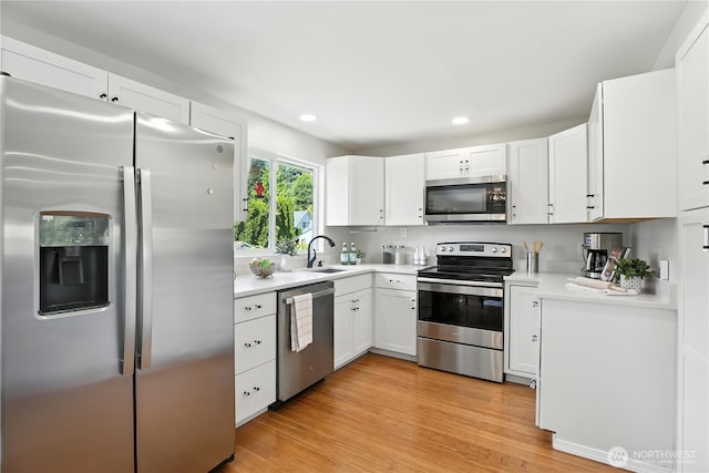 18844 SE 214th St, Renton, WA 98058 - kitchen with stainless steel appliances, light countertops, white cabinets, recessed lighting, and light wood finished floors