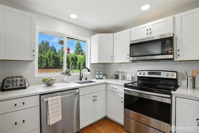 18844 SE 214th St, Renton, WA 98058 - kitchen featuring stainless steel appliances, light countertops, white cabinets, recessed lighting, and light wood finished floors