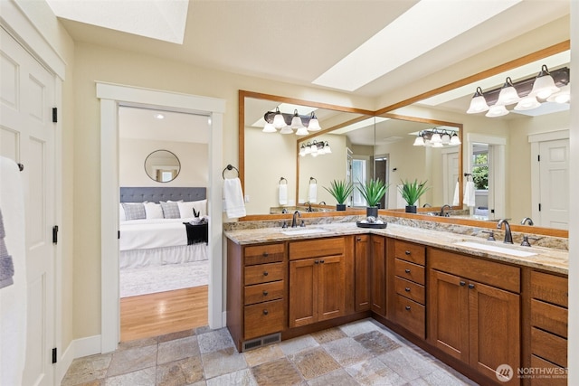4101 Banbridge Loop SE, Olympia, WA 98501 - bathroom with ensuite bath, double vanity, stone finish flooring, a skylight, and a chandelier