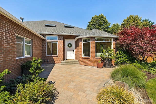 4101 Banbridge Loop SE, Olympia, WA 98501 - doorway to property featuring brick siding, roof with shingles, and a patio