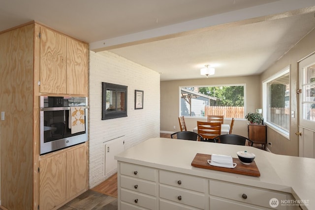 118 N Hemlock St, Soap Lake, WA 98851 - kitchen with oven, wood finished floors, light countertops, light brown cabinets, and brick wall