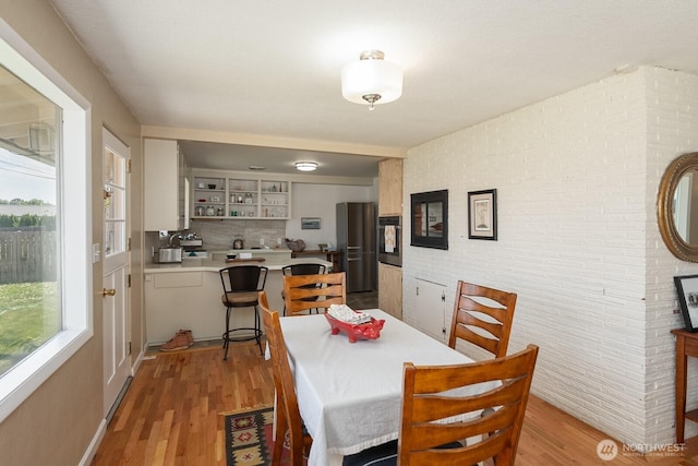 118 N Hemlock St, Soap Lake, WA 98851 - dining space featuring light wood-style floors and brick wall