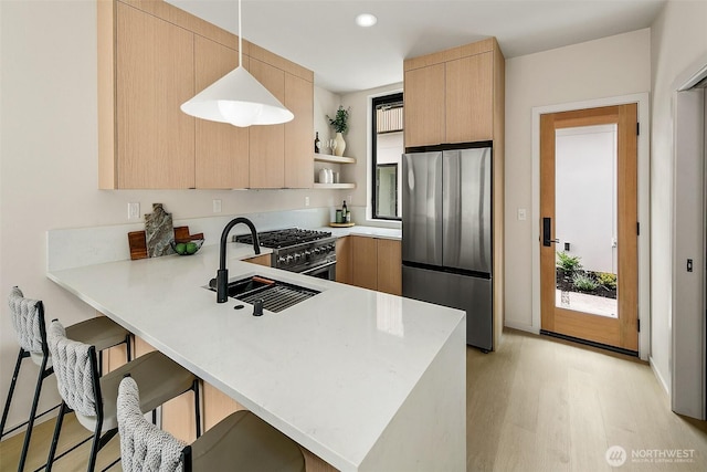 8733 13th Ave NW Unit A, Seattle, WA 98117 - kitchen with stainless steel appliances, light countertops, light brown cabinets, a peninsula, and open shelves