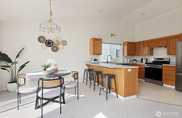 4896 Spinnaker Dr, Freeland, WA 98249 - kitchen featuring stainless steel appliances, a peninsula, light countertops, a breakfast bar, and brown cabinets