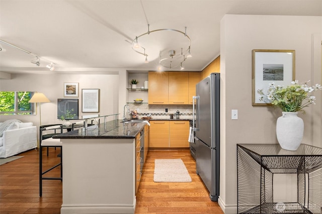 1420 E Pine St Unit E203, Seattle, WA 98122 - kitchen with freestanding refrigerator, rail lighting, open shelves, and light wood finished floors