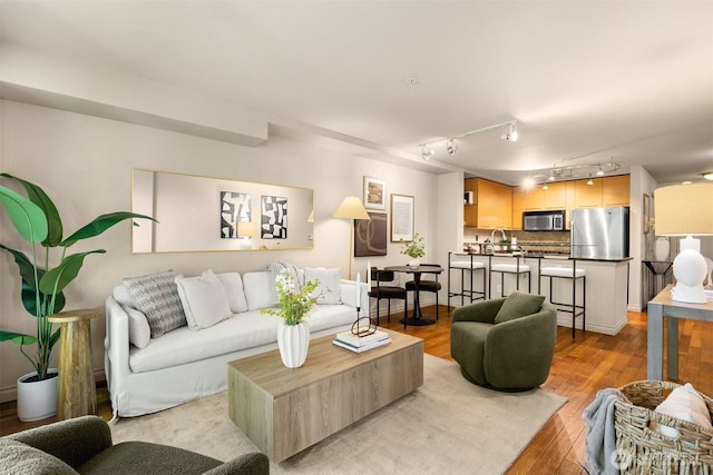 1420 E Pine St Unit E203, Seattle, WA 98122 - living room featuring wood finished floors and rail lighting