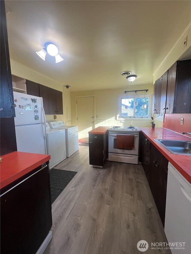 1717 Cherry St, Aberdeen, WA 98520 - kitchen featuring white appliances, light wood finished floors, washing machine and dryer, and a peninsula