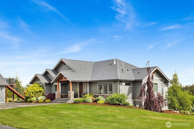 5754 W 26th Crst, Ferndale, WA 98248 - view of front of home with board and batten siding, a front yard, a shingled roof, and stone siding