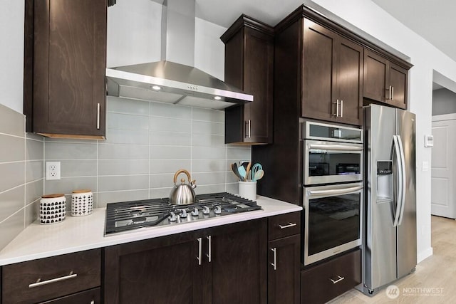 821 SE 12th Pl Unit 31, North Bend, WA 98045 - kitchen with wall chimney exhaust hood, appliances with stainless steel finishes, dark brown cabinets, light countertops, and tasteful backsplash