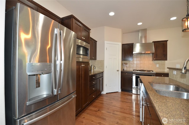 27719 NE 146th Way, Duvall, WA 98019 - kitchen with appliances with stainless steel finishes, wall chimney exhaust hood, wood finished floors, dark brown cabinets, and recessed lighting
