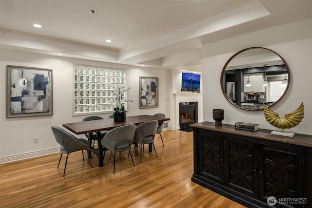 1416 6th Ave N, Seattle, WA 98109 - dining area with a tray ceiling, wood finished floors, a glass covered fireplace, and recessed lighting