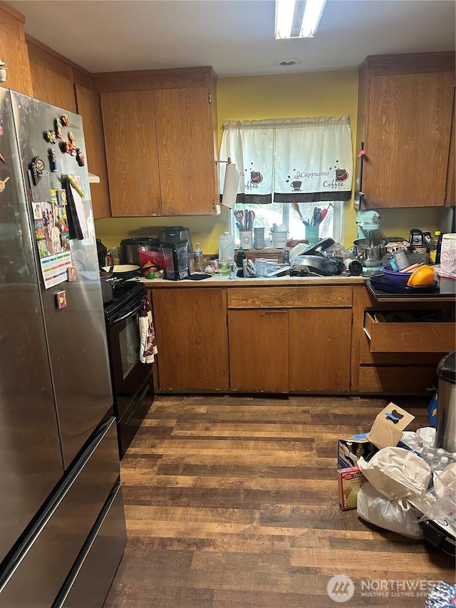 517 Juniper, Oroville, WA 98844 - kitchen with freestanding refrigerator, black range with electric stovetop, dark wood finished floors, and brown cabinetry