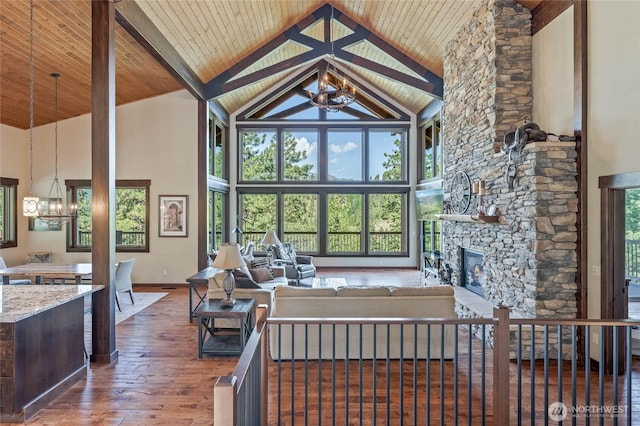 239 Foxridge Ln, Leavenworth, WA 98826 - living area with high vaulted ceiling, a chandelier, hardwood / wood-style flooring, a fireplace, and a wooden ceiling with exposed beams