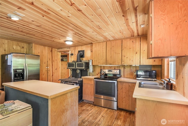13990 Brae Burn Rd, Leavenworth, WA 98826 - kitchen with appliances with stainless steel finishes, wooden ceiling, light countertops, wooden walls, and light wood finished floors