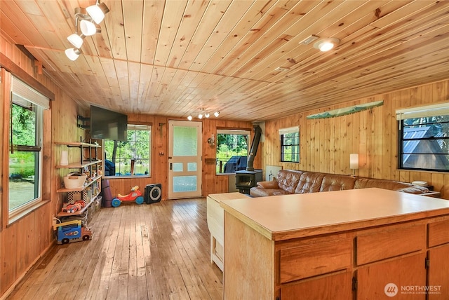 13990 Brae Burn Rd, Leavenworth, WA 98826 - home office featuring wooden walls, wooden ceiling, a wood stove, plenty of natural light, and light wood-style flooring