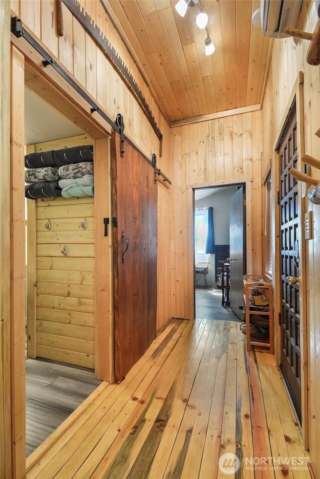 13990 Brae Burn Rd, Leavenworth, WA 98826 - hallway featuring a barn door, hardwood / wood-style flooring, wooden ceiling, and wooden walls