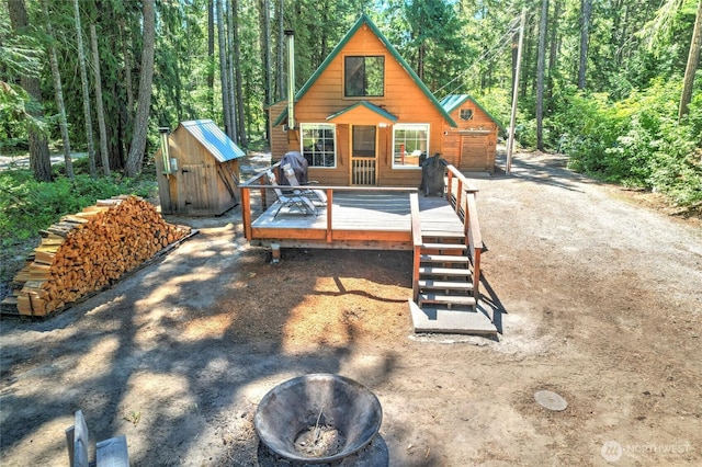 13990 Brae Burn Rd, Leavenworth, WA 98826 - back of house featuring an outdoor fire pit, a wooden deck, a shed, and a wooded view