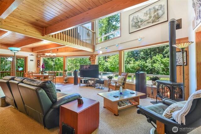 2115 Chiwawa Ct, Leavenworth, WA 98826 - carpeted living area with a wood stove, a wood ceiling with exposed beams, plenty of natural light, and a chandelier