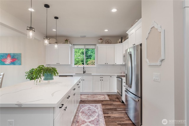10 Coyote Rd, Montesano, WA 98563 - kitchen featuring appliances with stainless steel finishes, a center island, white cabinetry, dark wood-type flooring, and backsplash
