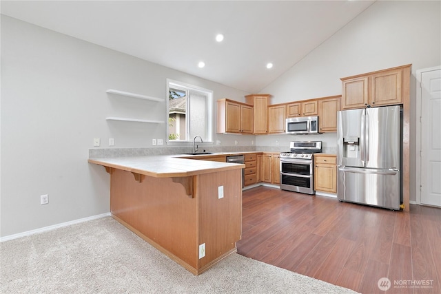 17915 25th Ave E, Tacoma, WA 98445 - kitchen with stainless steel appliances, a peninsula, light countertops, a breakfast bar area, and high vaulted ceiling