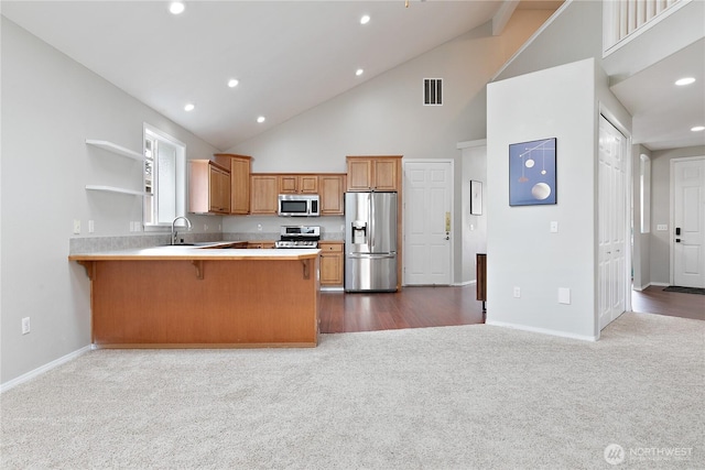 17915 25th Ave E, Tacoma, WA 98445 - kitchen featuring stainless steel appliances, dark carpet, a peninsula, open shelves, and high vaulted ceiling