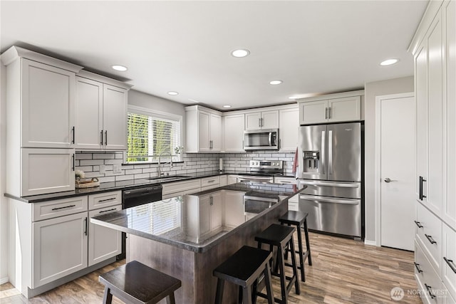 11389 Thompson Rd NE, Moses Lake, WA 98837 - kitchen featuring stainless steel appliances, a breakfast bar, backsplash, light wood-style floors, and recessed lighting