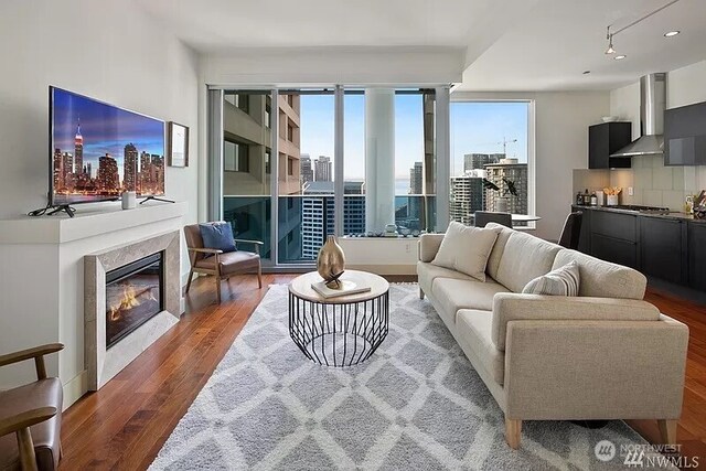 737 Olive Way Unit 3110, Seattle, WA 98101 - living room featuring wood finished floors, a glass covered fireplace, healthy amount of natural light, a city view, and recessed lighting