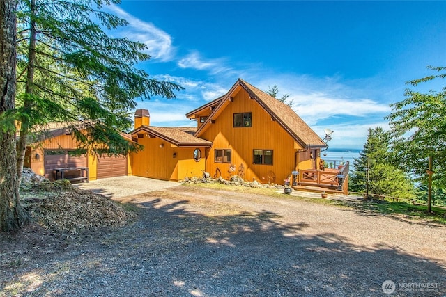 1669 Day Lake Rd, Orcas Island, WA 98245 - rear view of house featuring gravel driveway, a chimney, a shingled roof, and a garage