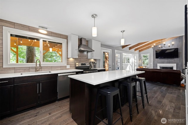 13 Westbrook Ct, Bellingham, WA 98229 - kitchen with wall chimney exhaust hood, appliances with stainless steel finishes, dark wood-style floors, light countertops, and a kitchen breakfast bar