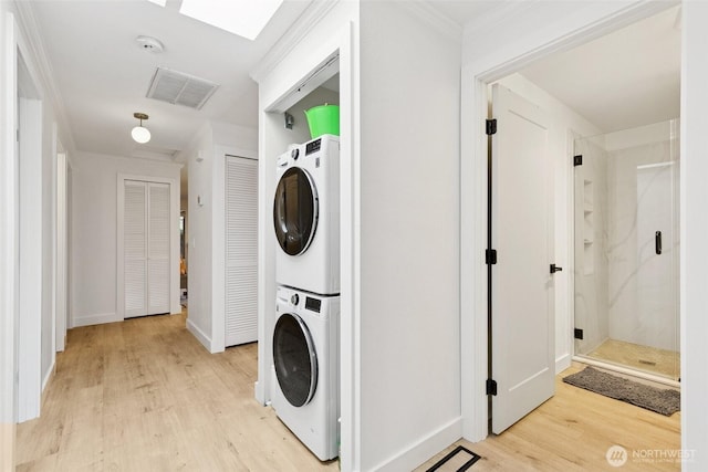 13216 NE 138th Pl, Kirkland, WA 98034 - laundry area featuring stacked washing machine and dryer, light wood finished floors, and ornamental molding