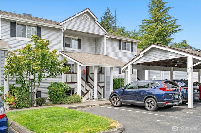 23335 Cedar Way Unit B204, Mountlake Terrace, WA 98043 - view of front of home with covered and uncovered parking, stairs, a shingled roof, and a front yard