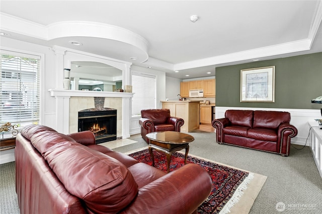 23335 Cedar Way Unit B204, Mountlake Terrace, WA 98043 - living area featuring a tray ceiling, ornamental molding, a tile fireplace, light colored carpet, and recessed lighting