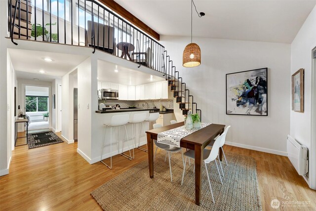 8941 Ravenna Ave NE, Seattle, WA 98115 - dining space with high vaulted ceiling, light wood-style flooring, stairway, and radiator