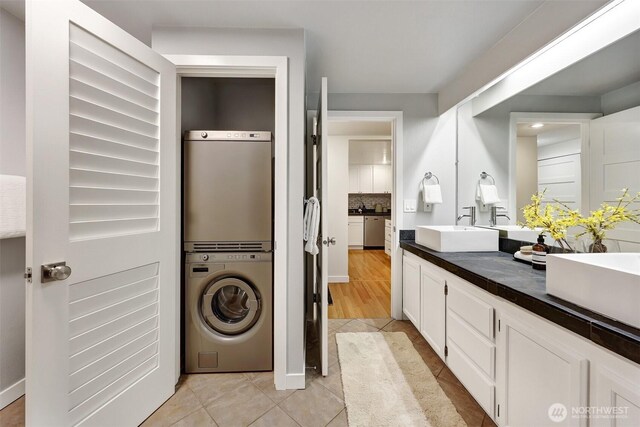 8941 Ravenna Ave NE, Seattle, WA 98115 - bathroom featuring estacked washer and dryer, double vanity, tile patterned flooring, and backsplash