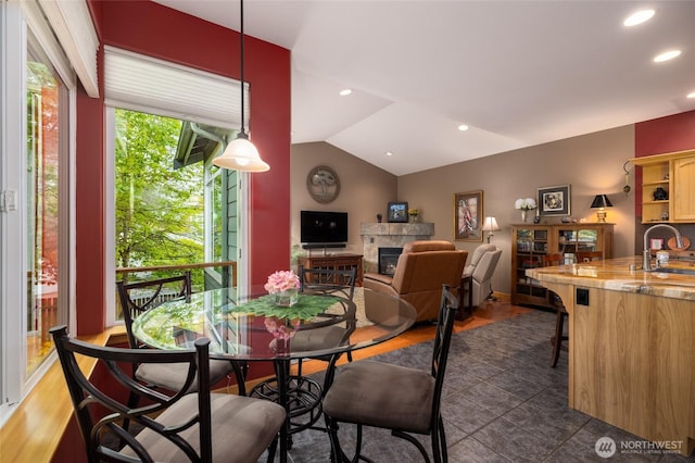 3205 Shelly Hill Rd, Mount Vernon, WA 98274 - dining area featuring a tile fireplace, lofted ceiling, recessed lighting, wood finished floors, and bar