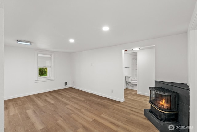 608 NE 2nd St, Winlock, WA 98596 - unfurnished living room with a wood stove, light wood-style flooring, and recessed lighting
