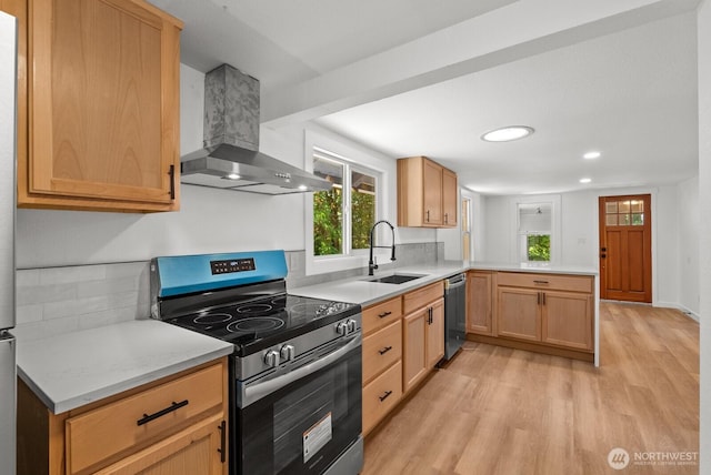 608 NE 2nd St, Winlock, WA 98596 - kitchen featuring stainless steel appliances, wall chimney range hood, light wood-style floors, a peninsula, and light countertops