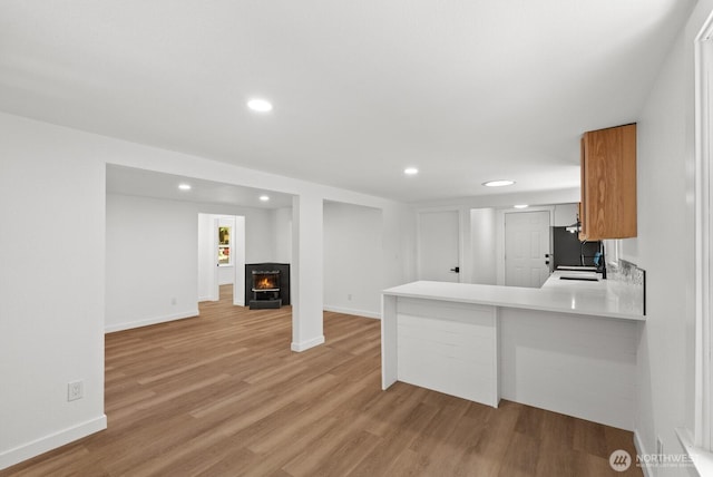 608 NE 2nd St, Winlock, WA 98596 - kitchen with freestanding refrigerator, light wood-type flooring, light countertops, recessed lighting, and a peninsula