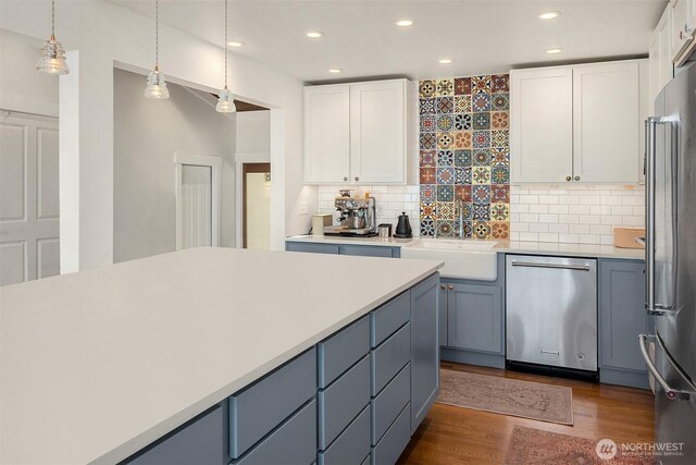10843 Point Vashon Dr SW, Vashon, WA 98070 - kitchen with appliances with stainless steel finishes, white cabinetry, dark wood finished floors, recessed lighting, and tasteful backsplash