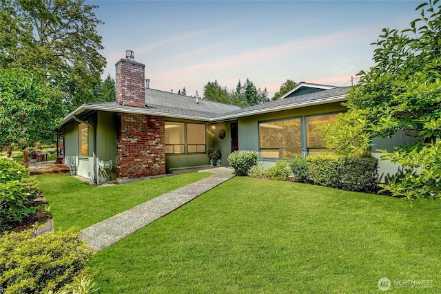 1323 216th Ave NE, Sammamish, WA 98074 - back of property at dusk featuring a chimney, a lawn, and roof with shingles