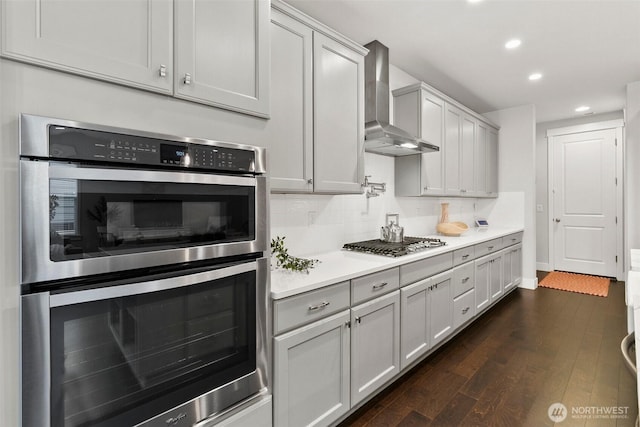 305 Field Pl SE, Renton, WA 98059 - kitchen featuring stainless steel appliances, wall chimney exhaust hood, recessed lighting, light countertops, and dark wood-type flooring