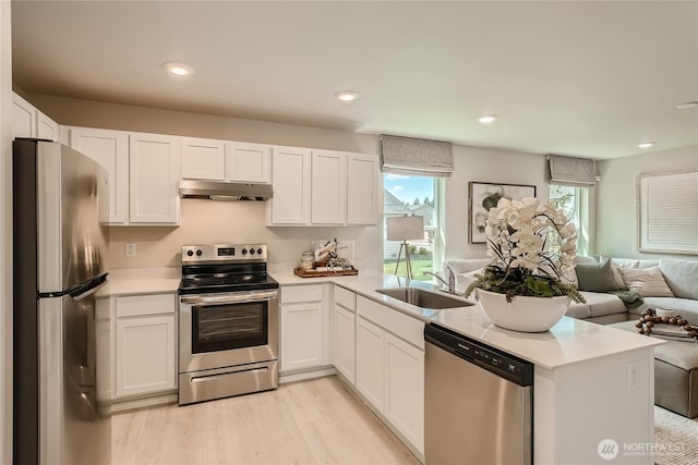 13908 198th St E, Graham, WA 98338 - kitchen featuring stainless steel appliances, under cabinet range hood, open floor plan, light countertops, and white cabinets