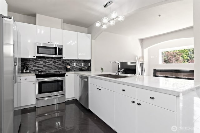 14335 Simonds Rd NE Unit A305, Kirkland, WA 98034 - kitchen with appliances with stainless steel finishes, a peninsula, tasteful backsplash, white cabinetry, and light countertops